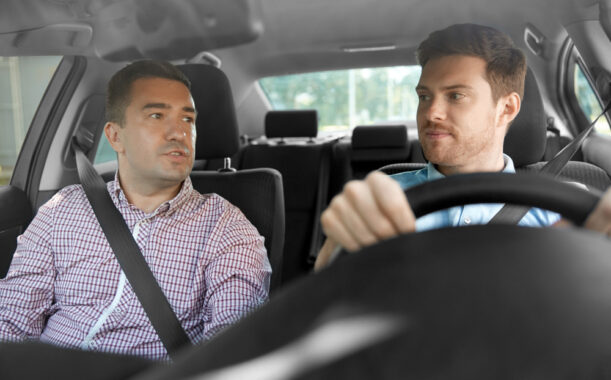 two men in front seats of car