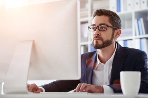 man on computer with coffee mug