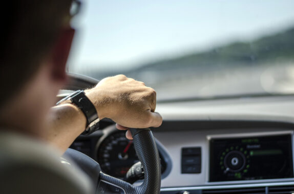 man driving down road behind wheel