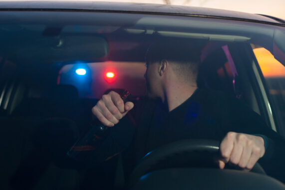 man getting pulled over with police lights behind him at night