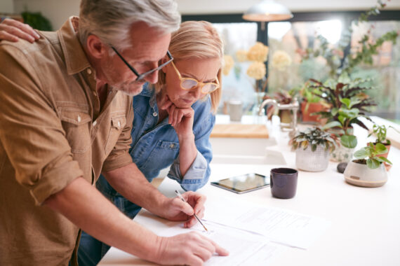 Mature couple looks over insurance papers