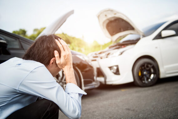 Young man holds his head in dismay after an accident