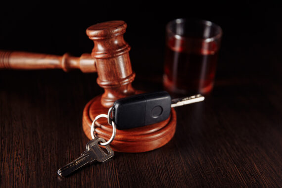 Still life of judge gavel, car keys and glass of whiskey