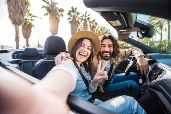 Happy couple drives in a convertible around Florida