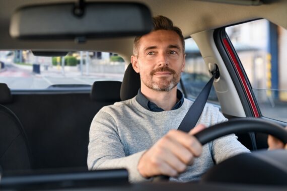 man looks in rearview mirror as he drives