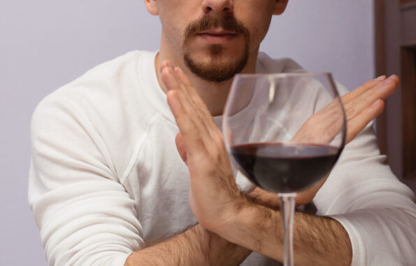 Man in background refuses glass of wine