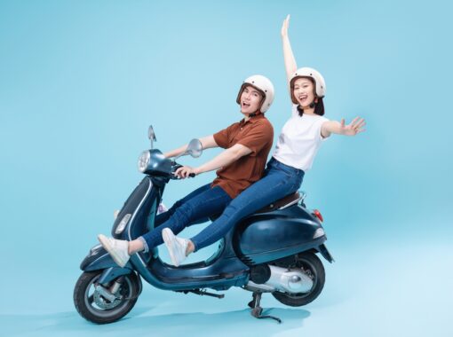 Young Asian couple posing on a scooter.